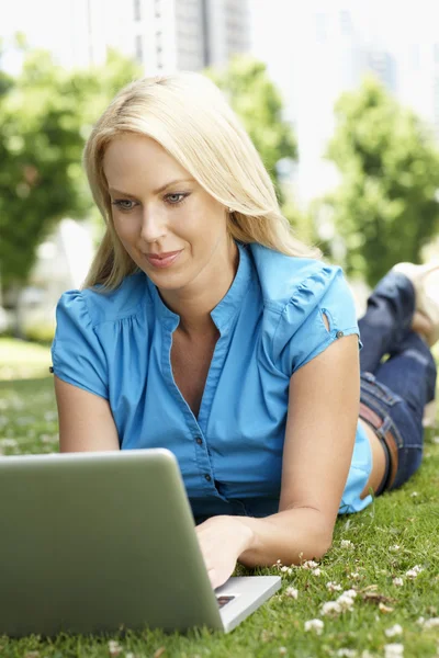 Kvinna med laptop i stadsparken — Stockfoto