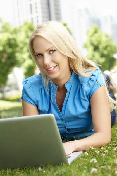Woman using laptop in city park — Stock Photo, Image