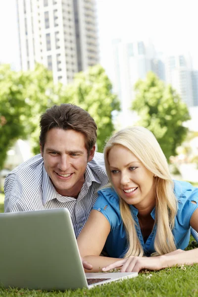 Couple using laptop in city park — Stock Photo, Image