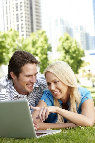 Couple using laptop in city park — Stock Photo, Image