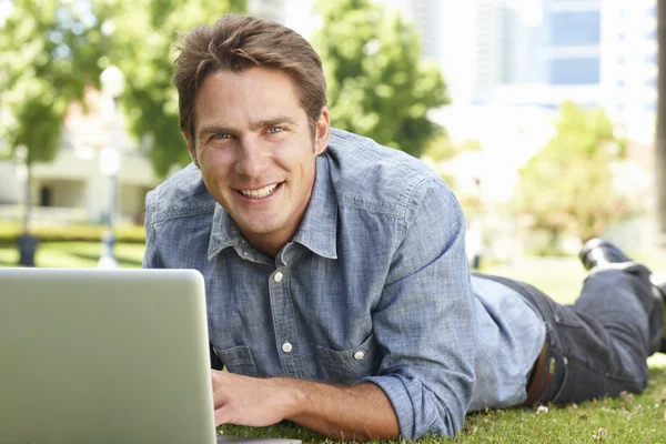 Mann benutzt Laptop im Stadtpark — Stockfoto