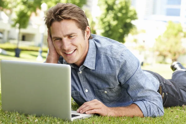 Człowiek korzysta z laptopa w parku — Zdjęcie stockowe