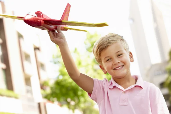 Мальчик на улице с игрушечным самолетом — стоковое фото