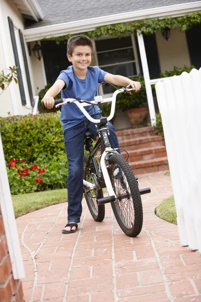 Хлопчик в саду з велосипедом — стокове фото