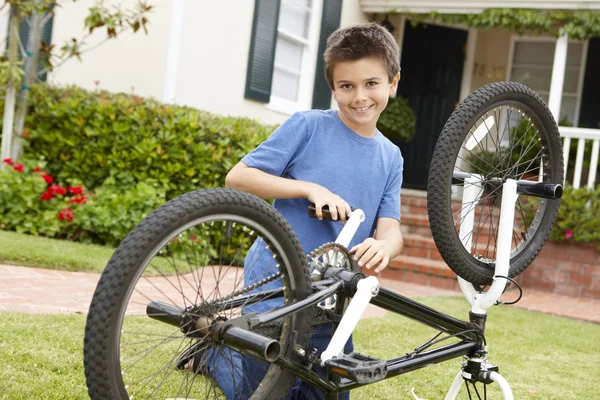 Pojke fastställande cykel i trädgården — Stockfoto