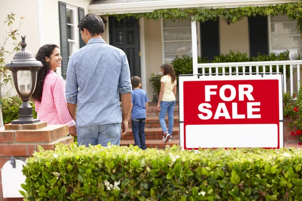 Spansktalande familj utanför hem med för försäljning tecken — Stockfoto