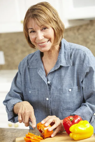 Donna di mezza età che taglia le verdure — Foto Stock