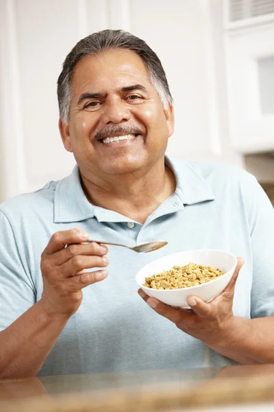 Senior man eating cereal — Stock Photo, Image