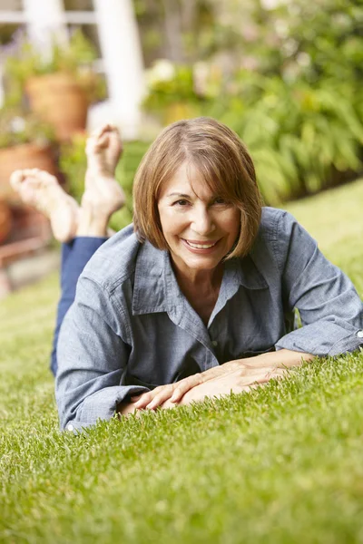 Střední věk žena relaxační v zahradě — Stock fotografie