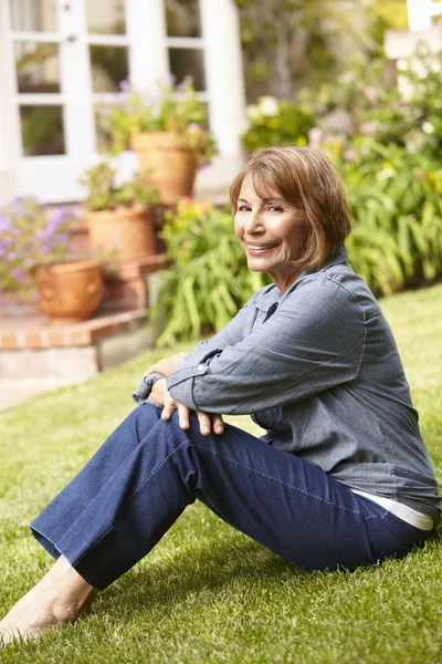 Mujer de mediana edad relajándose en el jardín — Foto de Stock