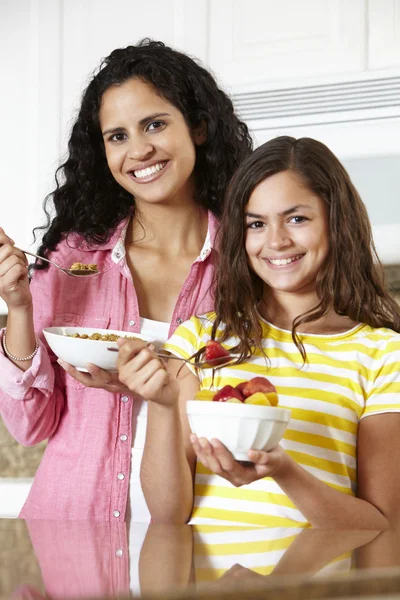 Moeder en dochter eten granen en fruit — Stockfoto