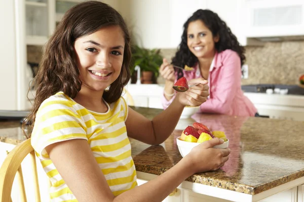 Moeder en dochter eten granen en fruit — Stockfoto