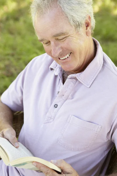Senior man läser en bok — Stockfoto