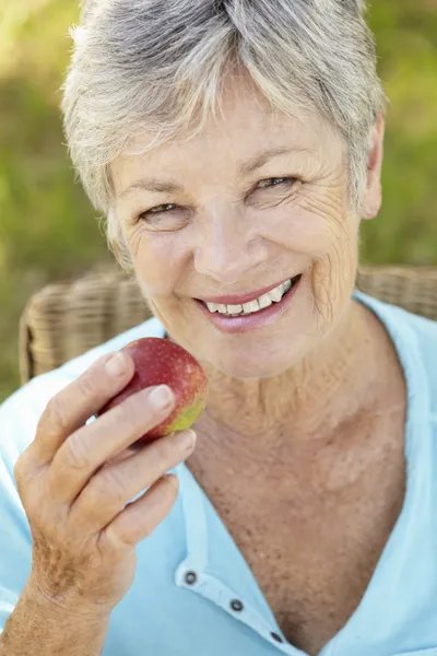 Äldre kvinna äta äpple — Stockfoto