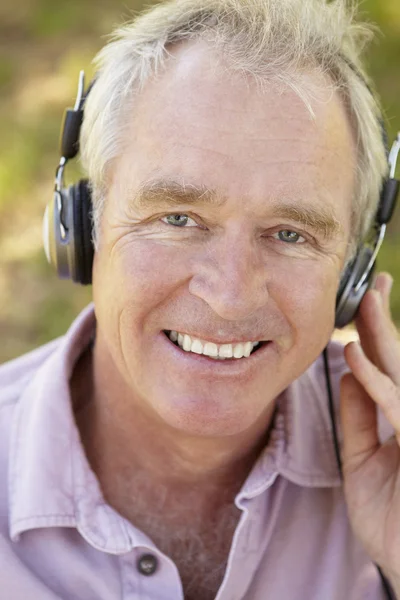 Starší muž s sluchátka — Stock fotografie