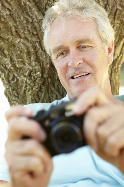 Senior man met camera — Stockfoto