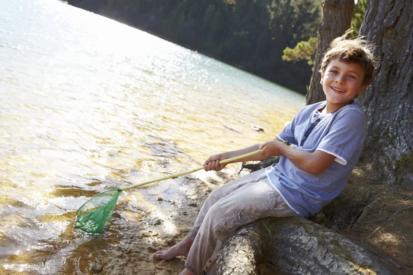 Rapaz feliz pesca no lago — Fotografia de Stock