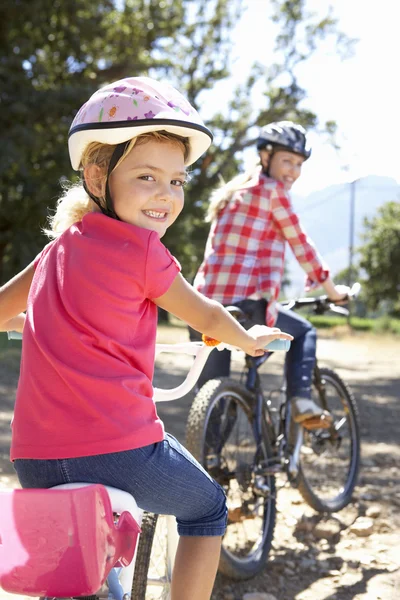 Маленькая девочка на велосипеде с мамой — стоковое фото