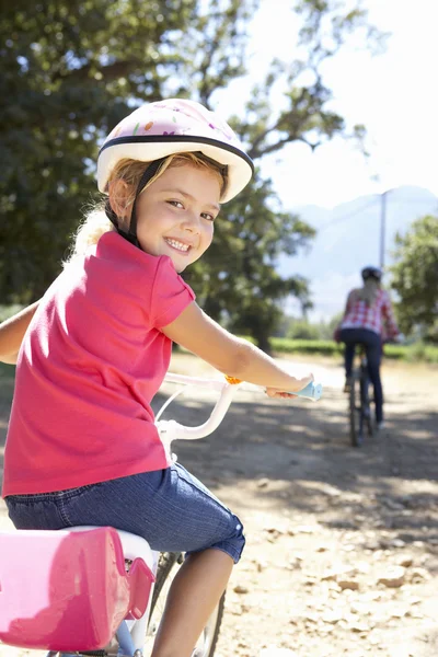 Menina no país passeio de bicicleta com a mãe — Fotografia de Stock