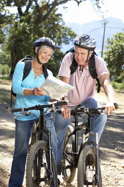 Coppia anziana con mappa in bici di campagna — Foto Stock