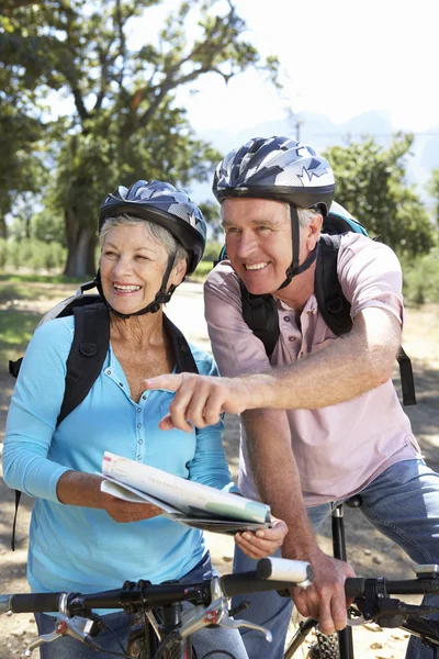 Coppia anziana con mappa in bici di campagna — Foto Stock