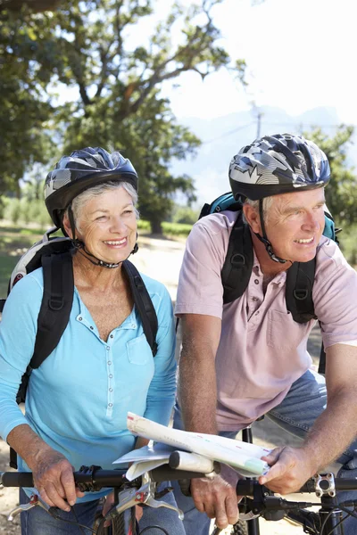 Starší pár s mapou na zemi na kole jezdit — Stock fotografie