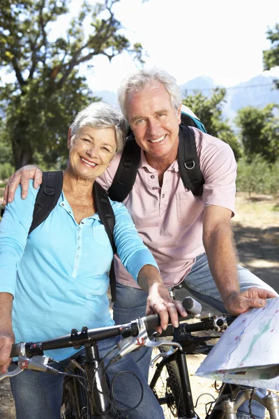 カントリー自転車地図と年配のカップルに乗る — ストック写真