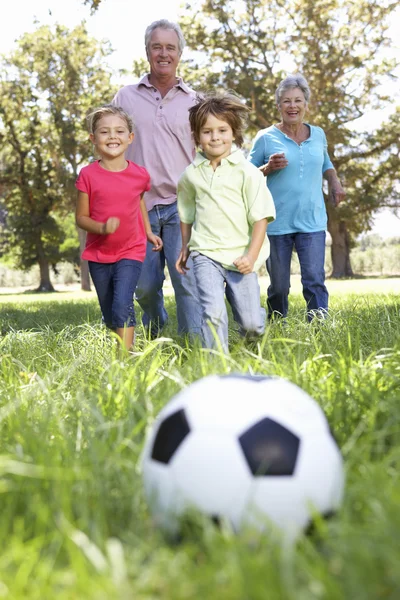 Farföräldrar spelar fotboll med grandchilderen — Stockfoto