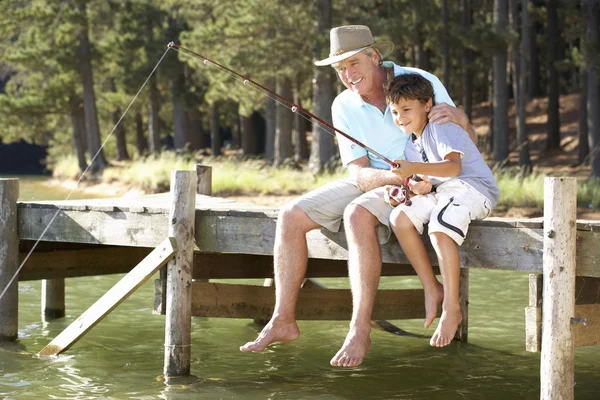 Senior man fishing with grandson — Stock Photo, Image