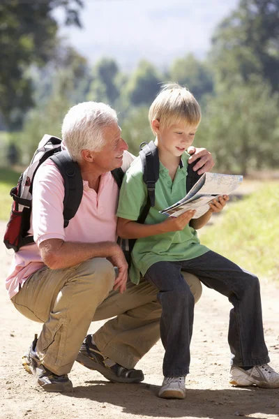 Äldre man läsa karta med barnbarn på land promenad — Stockfoto