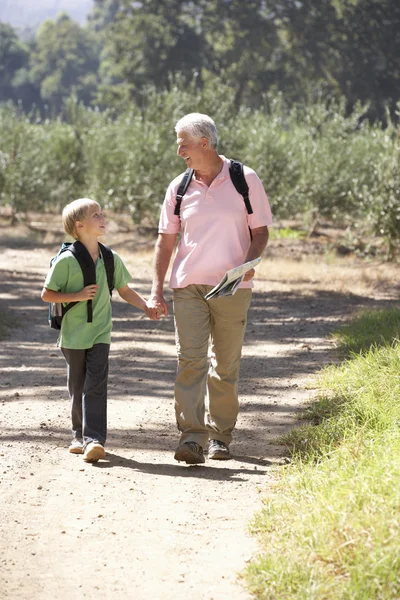 Senior man and grandson on country walk — Stock Photo, Image