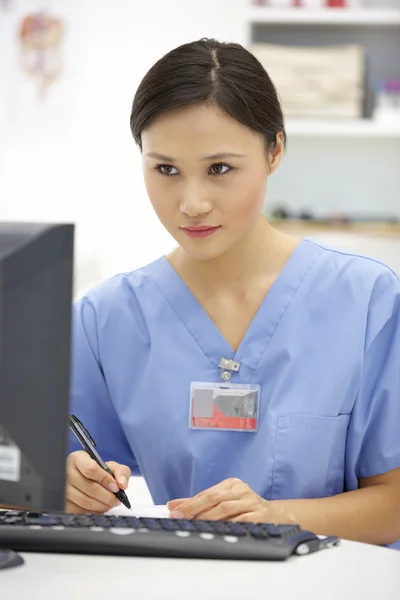 Junger Krankenhausarzt am Schreibtisch — Stockfoto