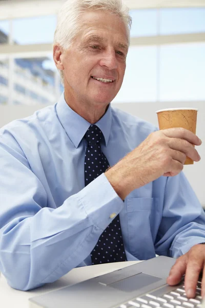 Senior zakenman met laptop en koffie — Stockfoto