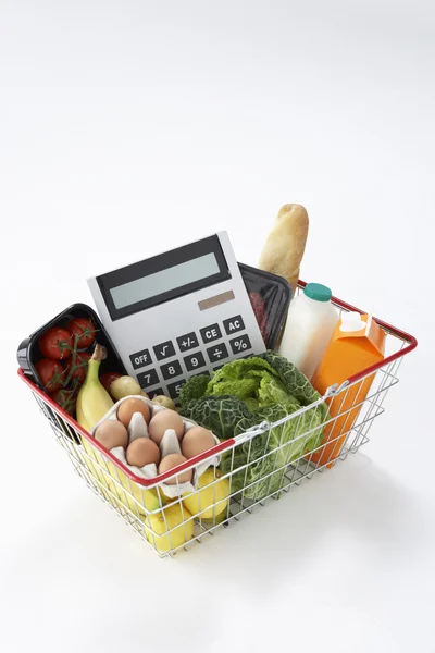 Basket of groceries and calculator — Stock Photo, Image
