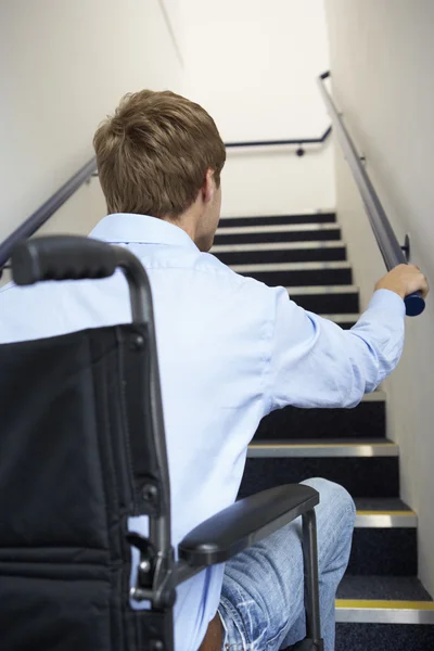 Человек в инвалидном кресле у подножия лестницы — стоковое фото