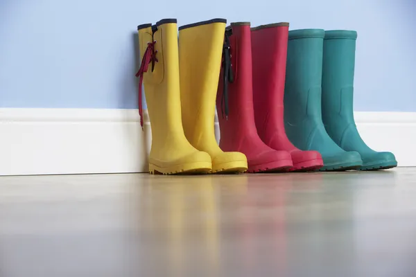 Wellingtons lines up against wall — Stock Photo, Image