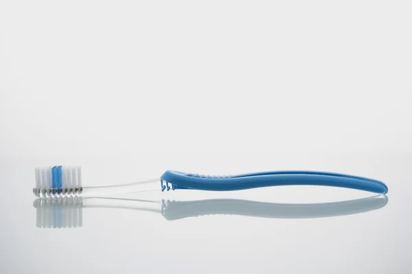 Escova de dentes deitada na prateleira de vidro — Fotografia de Stock