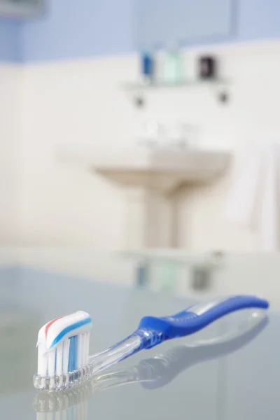 Escova de dentes com pasta de dentes no banheiro — Fotografia de Stock