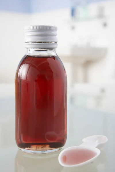Лекарство от кашля на полке ванной — стоковое фото