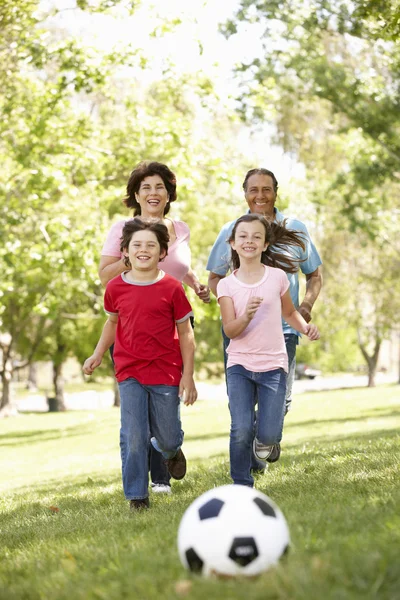 Family playing football in park — Stock Photo, Image