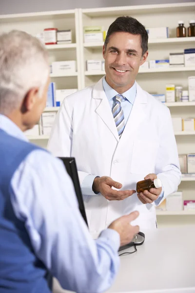 Farmacéutico americano con hombre mayor en farmacia —  Fotos de Stock
