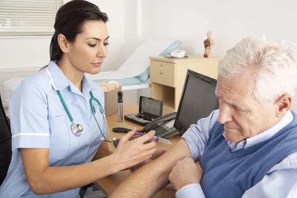 Enfermeira britânica dando injeção ao homem idoso — Fotografia de Stock