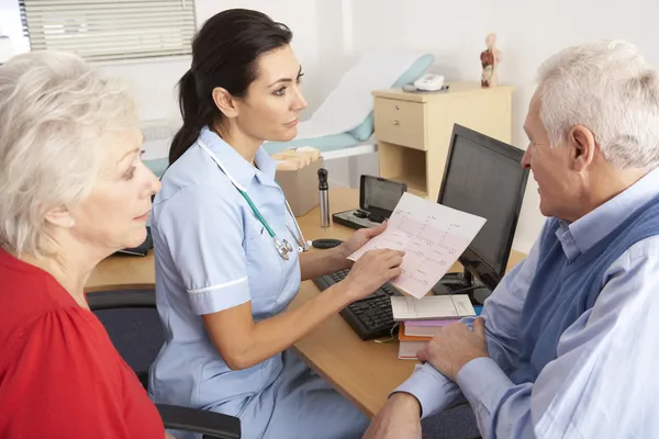 Britse verpleegster praten met senior koppel — Stockfoto