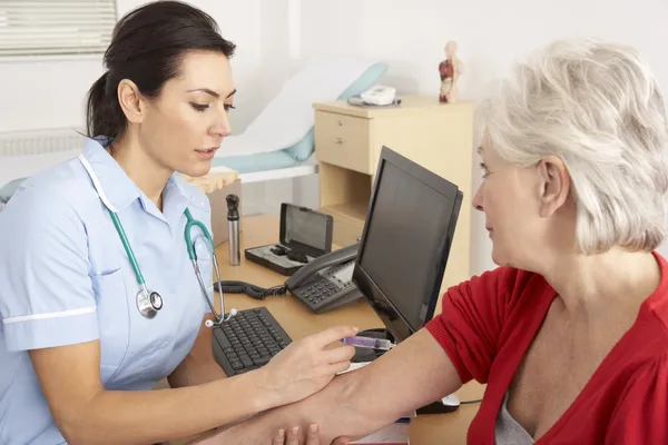 Enfermeira britânica a administrar injecção a mulher idosa — Fotografia de Stock