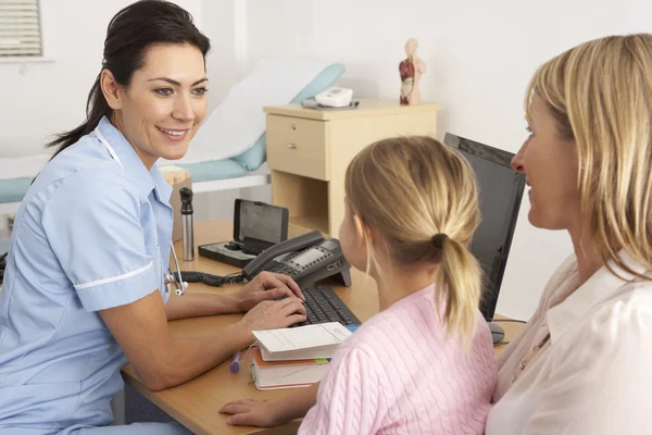 Britse verpleegster in gesprek met jonge kind en moeder — Stockfoto