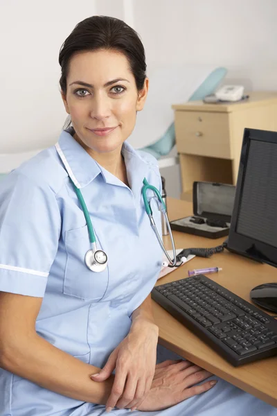 Brittisk sköterska sitter vid skrivbord på jobbet — Stockfoto