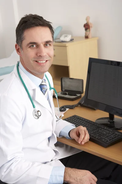 Amerikanischer Arzt sitzt am Schreibtisch — Stockfoto