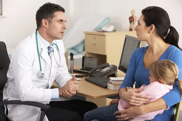 Американский врач разговаривает с обеспокоенной матерью — стоковое фото