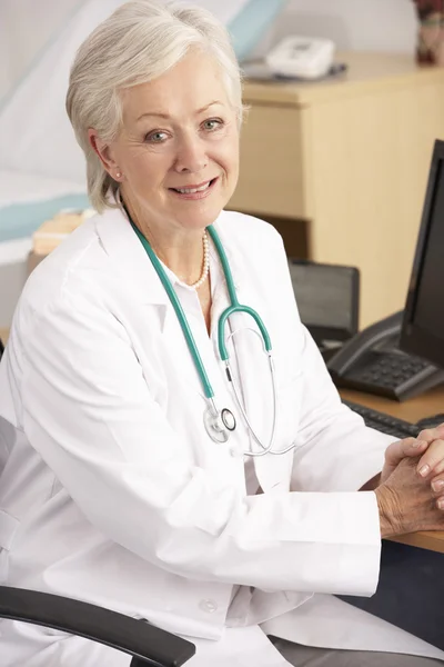 American female doctor sitting at desk — Stock Photo, Image