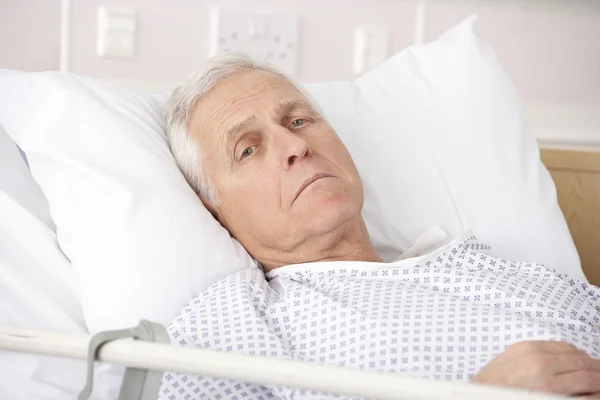Starší muž v nemocniční posteli nemocný — Stock fotografie